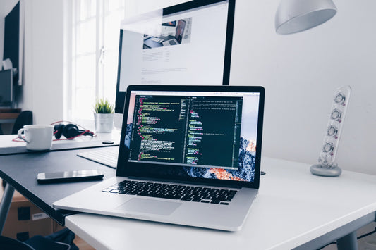 Laptop on a desk in a bright white room. 